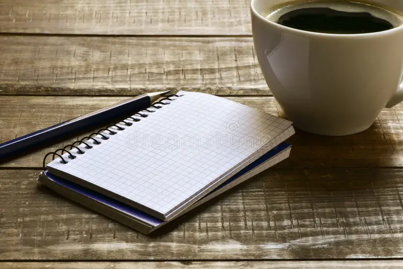 cuaderno-pluma-y-taza-de-café-en-blanco-64871210